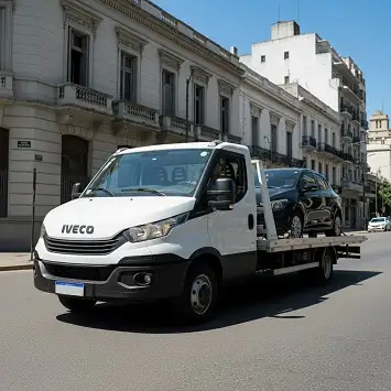 Grúa remolcando auto por calle de zona sur