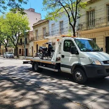 Grúa remolcando una moto azul